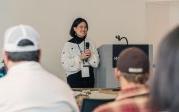 A woman speaks to a group of people.